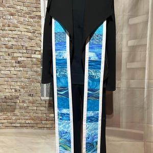May include: A blue and white patterned stole with a white border. The stole is made of fabric and has a design of waves and water.