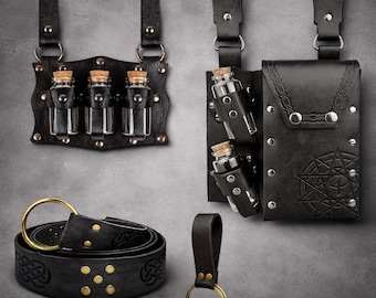 Peut inclure: Ensemble d'accessoires en cuir noir, comprenant une ceinture à boucle dorée, un porte-clés et des supports pour petites bouteilles en verre avec bouchons en liège. Les accessoires sont ornés de clous métalliques et de motifs celtiques.