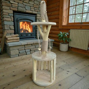 Peut inclure: Un arbre à chat en bois naturel avec une base ronde et une plateforme. L'arbre est doté d'un poteau central enveloppé de corde, avec des jouets en corde suspendus. L'arbre à chat est conçu pour que les chats puissent jouer et se détendre.