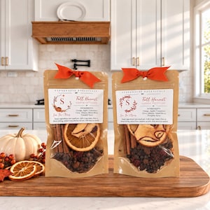 May include: Two kraft paper pouches of Stonehouse Botanicals Fall Harvest simmer potpourri, each topped with an orange ribbon. The labels list ingredients including orange, apple, cinnamon, clove, allspice, mixed berry, and pumpkin spice.