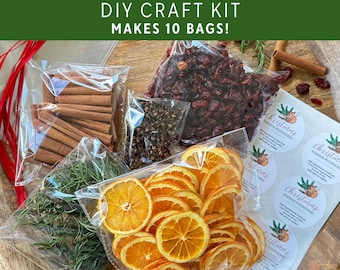 May include: A Christmas simmer potpourri DIY craft kit containing clear plastic bags filled with dried orange slices, cinnamon sticks, dried cranberries, cloves, and rosemary sprigs, plus a sheet of circular labels with the text Christmas Simmer Potpourri.