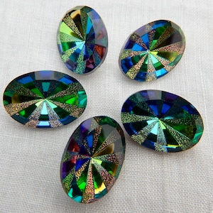 May include: Five oval-shaped dichroic glass cabochons. The cabochons feature a vibrant display of colors, including green, blue, and gold, arranged in a radial pattern. The glass has a reflective, iridescent quality.