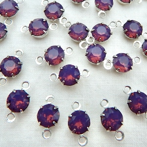 May include: A collection of 20 purple rhinestone connector charms with silver-toned metal loops. Each charm features a round rhinestone with a faceted design.