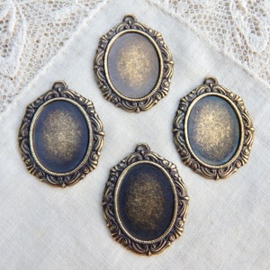 May include: Four antique gold-toned metal oval picture frames with ornate detailing. Each frame has a smooth, slightly textured surface and a raised lip around the edge.