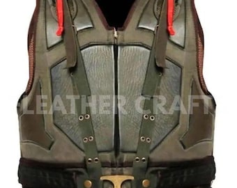 May include: A tactical vest in olive green and grey, with a distressed, textured finish. It has a central zip, multiple straps, and red pull tabs on the shoulders. The text "LEATHER CRAFT" is printed on the vest. The vest has a military-inspired design.