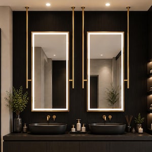May include: A double vanity bathroom set featuring two oval black vessel sinks, two rectangular LED-lit mirrors suspended by gold metal rods, a dark wood floating cabinet with an open lower shelf, and gold wall-mounted faucets.