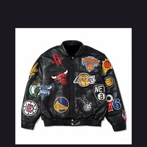Puede incluir: Chaqueta bomber de cuero negro con varios parches de equipos de la NBA. Los parches incluyen logotipos de los Rockets, Bulls, Lakers y otros. La chaqueta tiene cierre de botones y cuello y puños acanalados.