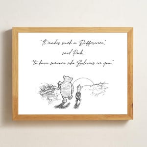 May include: A framed print featuring a black and white illustration of Winnie the Pooh and Piglet walking together. The quote "It makes such a Difference, said Pooh, to have someone who Believes in you" is written above the illustration.