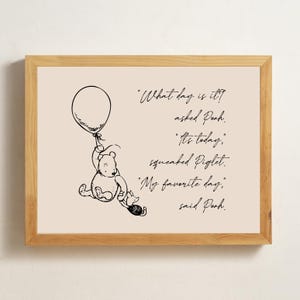 May include: A framed print with a black and white illustration of Winnie the Pooh and Piglet. The text reads: "What day is it?" "It's today." "My favourite day."