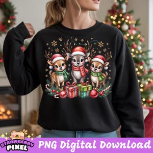 May include: Black sweatshirt featuring a festive design with three cartoon reindeer wearing Santa hats and scarves. The reindeer are surrounded by snowflakes, gifts, and candy canes. The text "PNG Digital Download" is at the bottom.