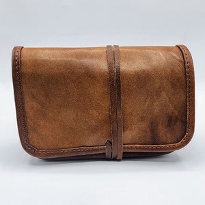 Pochette en cuir vieilli remplie d'éphémères pour un journal indésirable, un carnet de notes de voyage ou un agenda