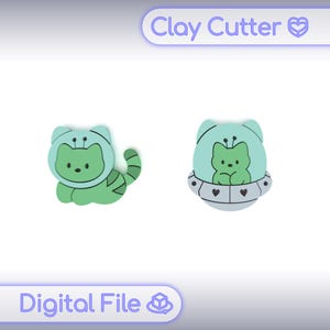 Puede incluir: Dos cortadores de arcilla verdes con diseño de gato. Un gato lleva un casco espacial, el otro está en una nave espacial. El texto "Clay Cutter" y "Digital File" está en la imagen.