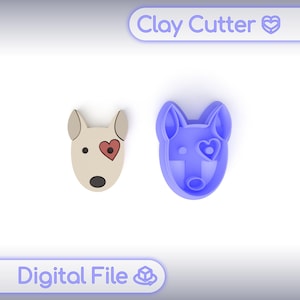 Può includere: Un tagliapasta blu e un pezzo di argilla finito a forma di testa di cane. Il pezzo finito è beige con un cuore rosso e un naso nero. Il testo "Clay Cutter" e "Digital File" sono visibili.