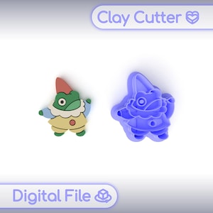 May include: A colourful clay cutter and a finished clay figure of a gnome. The gnome has a red hat, green face, and a yellow outfit. The clay cutter is blue and in the shape of the gnome. The text "Clay Cutter" and "Digital File" are visible.