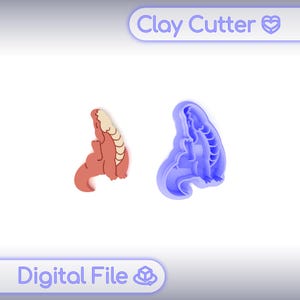 Pode incluir: Um cortador de argila azul e uma figura de dinossauro de argila acabada. A figura acabada é vermelha com barriga e costas bege. As palavras "Clay Cutter" e "Digital File" estão na imagem.