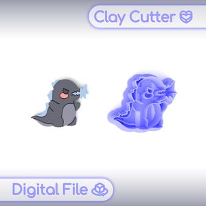 May include: A gray cartoon dinosaur clay cutter and a digital file of the same dinosaur. The clay cutter is blue and shows the outline of the dinosaur. The text "Clay Cutter" and "Digital File" are in the image.