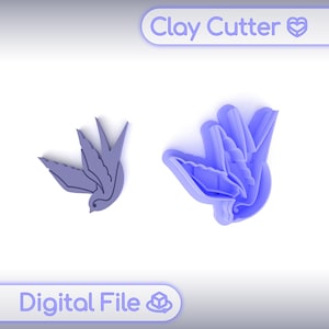 Puede incluir: Dos cortadores de arcilla azules con forma de golondrina. Uno es una forma sólida de pájaro y el otro es un molde. Las palabras "Clay Cutter" y "Digital File" están en la imagen.