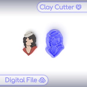 Op de afbeelding: Een blauwe kleisnijder en een afgewerkte kleifiguur van een vrouw met een hoed en een rode top. De afgewerkte figuur is in kleur. De tekst "Clay Cutter" en "Digital File" staat in de afbeelding.