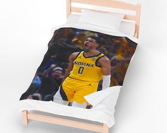 May include: A yellow and black basketball jersey with the word "INDIANA" and the number "0" is featured on a white blanket. The blanket is on a wooden bed frame. The image shows a basketball player in action.