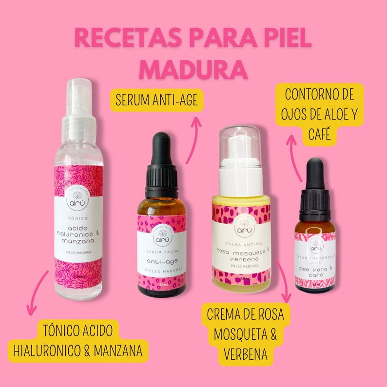 May include: Four glass bottles with pink and white labels containing skincare products for mature skin. The bottles are labelled with the words "T&oacute;nico &aacute;cido hialur&oacute;nico & manzana", "Serum facial anti-age", "Crema anti-age rosa mosqueta & verbena", and "Aloe vera & caf&eacute;".