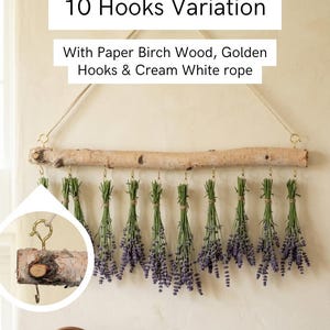 May include: A wall-hanging display featuring a horizontal paper birch wood branch suspended by a cream white rope. Ten golden hooks are attached to the branch, each holding a bundle of dried purple lavender. Text reads 10 Hooks Variation.