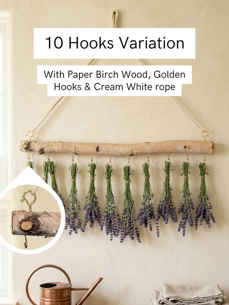 May include: A wall-hanging display featuring a horizontal paper birch wood branch suspended by a cream white rope. Ten golden hooks are attached to the branch, each holding a bundle of dried purple lavender. Text reads 10 Hooks Variation.
