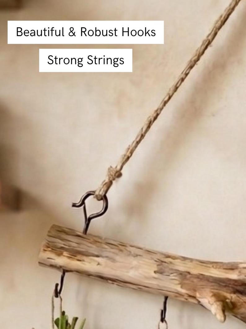 May include: A natural wooden branch suspended by a twisted jute string attached to a dark metal hook. The text "Beautiful & Robust Hooks" and "Strong Strings" is visible. The branch features additional small metal hooks for hanging items.
