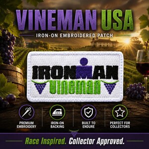 May include: A rectangular white embroidered patch featuring the black text IRONMAN and green text VINEMAN with purple grape cluster icons on each side. The patch has a white border and is displayed against a vineyard background with text.