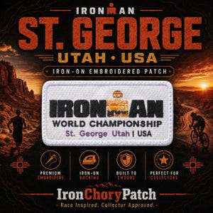May include: A rectangular white embroidered iron-on patch featuring the black text IRONMAN with a stylised sun icon replacing the letter O. Below this, the text reads WORLD CHAMPIONSHIP and St. George Utah | USA in purple lettering.