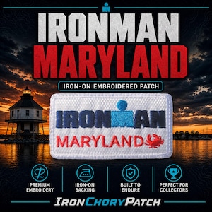 Puede incluir: Un parche bordado termoadhesivo rectangular con fondo blanco, el texto IRONMAN en azul oscuro y azul claro, y el texto MARYLAND en rojo junto a un pequeño gráfico de un cangrejo rojo. El parche tiene un borde blanco bordado.