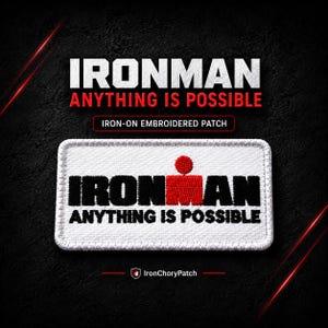 May include: A rectangular iron-on embroidered patch featuring a white background with black text that reads IRONMAN and red text that reads ANYTHING IS POSSIBLE. The design includes a red dot above a red square, mimicking the letter M in the text.