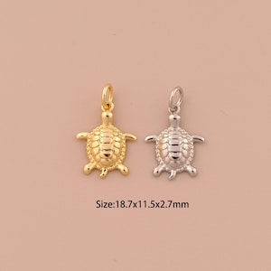 May include: Two turtle charms, one gold and one silver, with a textured shell design. Size: 18.7 x 11.5 x 2.7 mm.