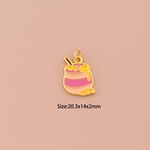 Puede incluir: Un charm dorado con forma de tarro de miel con esmalte rosa y amarillo. El charm tiene una cuchara dentro y miel goteando por el lateral. Tamaño: 20,3x14x2mm.