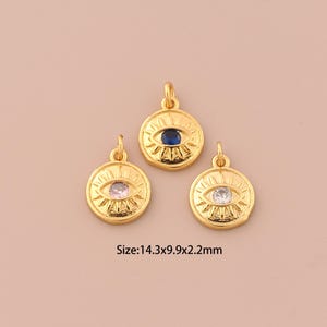Puede incluir: Tres colgantes de ojo turco dorados con piedras preciosas de diferentes colores. Los colgantes miden 14,3 mm de ancho, 9,9 mm de alto y 2,2 mm de grosor.