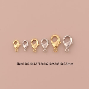 May include: Five silver and gold lobster clasps of different sizes. The clasps are arranged in order of size from smallest to largest. The text "Size: 15x7.5x3.5/12x7x2.5/9.7x5.5x2.5mm" is below the clasps.