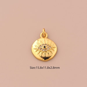 Puede incluir: Encanto de colgante dorado con un diseño de ojo malvado detallado con diamantes de imitación transparentes y negros. El colgante mide 15,8 mm x 11,8 mm x 2,8 mm.