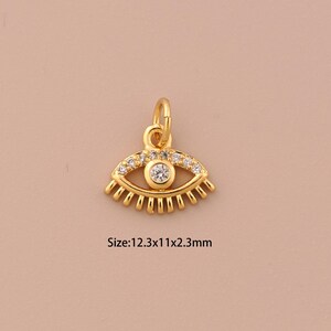 Puede incluir: Encanto de ojo turco dorado con detalles de cristal transparente. El encanto mide 12,3 mm de ancho, 11 mm de alto y 2,3 mm de grosor. Tamaño: 12,3x11x2,3 mm