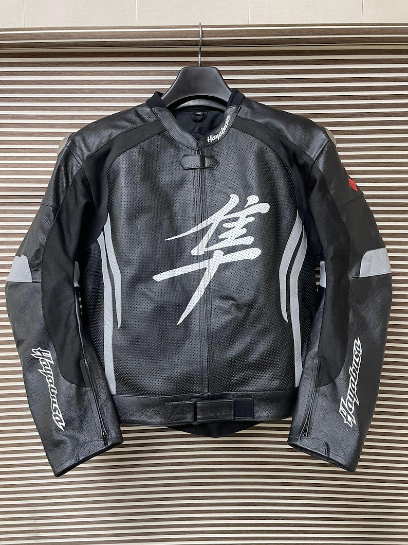 May include: Black leather motorcycle jacket with white accents and the word "Hayabusa" on the sleeves and back. The jacket has a white kanji character on the front.