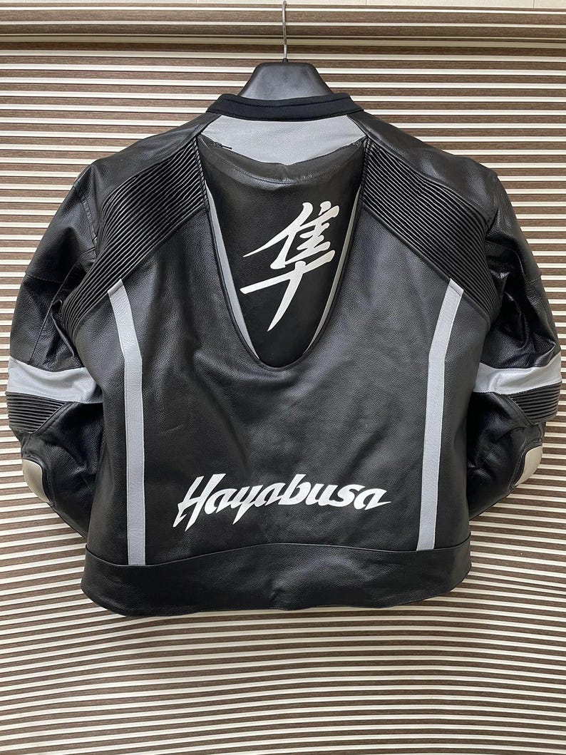 May include: Black leather motorcycle jacket with white accents and the word "Hayabusa" printed on the back. The jacket has a large white kanji character on the back.
