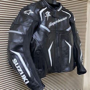 May include: Black leather motorcycle jacket with white accents and the text "Hayabusa" and "Suzuki" on the front and sleeves.