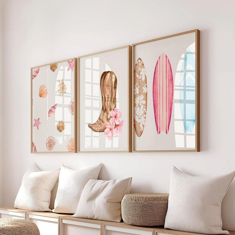 May include: Three framed prints with a beach theme. The left print features a pattern of seashells and starfish. The center print shows a brown cowboy boot with pink flowers. The right print shows three surfboards with floral and striped designs.