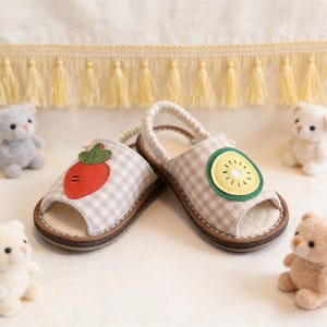 May include: A handmade wooden sign displaying the word "Welcome" in a playful font. The white-painted sign has a distressed finish, and is decorated with a floral design in pink and green hues. Suitable for indoor or outdoor use.