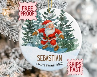 Peut inclure: Ornement de Noël rond avec le Père Noël faisant du snowboard. Le Père Noël porte un costume rouge et un bonnet, avec une barbe blanche. Le nom "Sebastian" et l'année "Christmas 2025" sont imprimés.