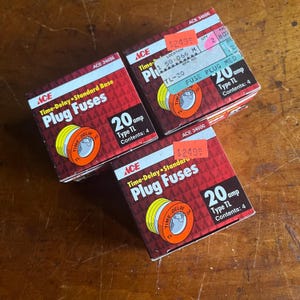 May include: Three boxes of 20 amp time-delay plug fuses. Each box is red and white with the words "Time-Delay Standard Base Plug Fuses" and "20 amp Type TL Contents: 4".