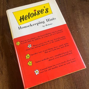May include: A vintage book titled "Heloise's Housekeeping Hints" by Heloise. The book has a white and yellow cover with red accents. The cover text includes tips for saving money and time on household tasks.