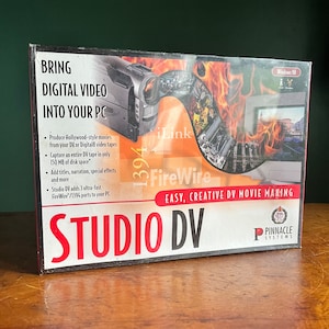 May include: A box for Pinnacle Systems Studio DV software for Windows 98. The box features a red and orange background with a camcorder and a computer monitor. The text "BRING DIGITAL VIDEO INTO YOUR PC" is in large, bold, white letters. The text "EASY, CREATIVE DV MOVIE MAKING" is in smaller, white letters. The text "STUDIO DV" is in large, red letters.