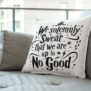 Op de afbeelding: Een wit kussen met zwarte tekst die "We solemnly swear that we are up to no good." luidt. De tekst is in een speels lettertype en bevat een afbeelding van een tovenaarshoed.