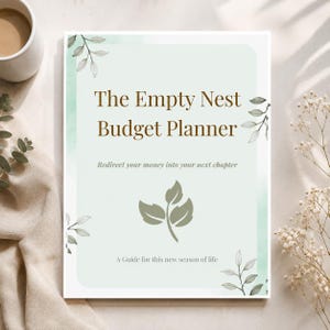 May include: A rectangular budget planner with a pale green background and watercolor leaf accents. The text reads: The Empty Nest Budget Planner, Redirect your money into your next chapter, and A Guide for this new season of life. A central leaf icon is visible.