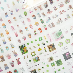 May include: A sheet of clear sticker paper featuring a variety of adorable cartoon characters, plants, and other designs. The stickers are ideal for decorating planners, journals, and other items.