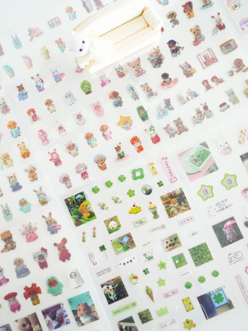 May include: A sheet of clear sticker paper featuring a variety of adorable cartoon characters, plants, and other designs. The stickers are ideal for decorating planners, journals, and other items.